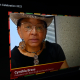 a woman wearing a hat and glasses on a television screen.