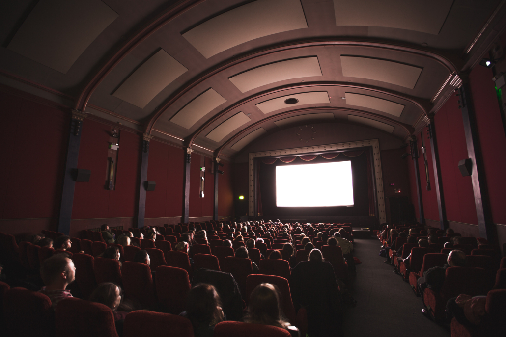 a movie theater with a large screen and red walls.