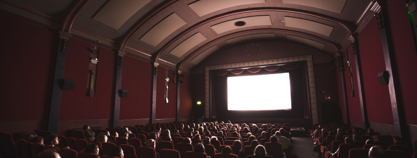 a movie theater with a large screen and red walls.