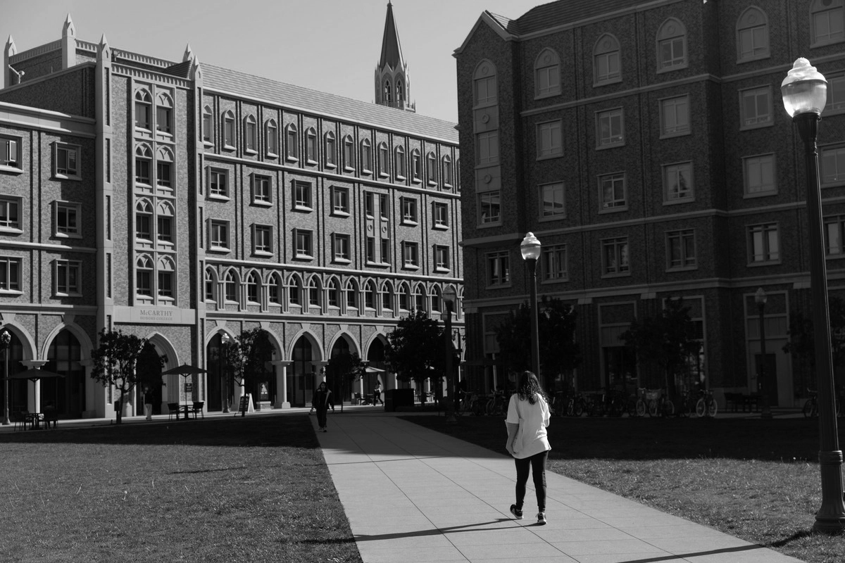 A person walking into USC Village plaza outside.