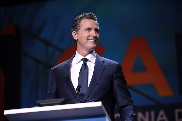 Gavin Newsom at podium, smiling