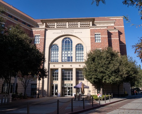 The front of the Engemann Student Health Center, a red brick building with a cream-colored entrance.