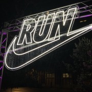 A neon Nike sign illuminating the night at the Nike After Dark tour's stop at USC Village.