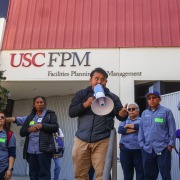 Protestors stand in front of the Facilities Planning and Management team.