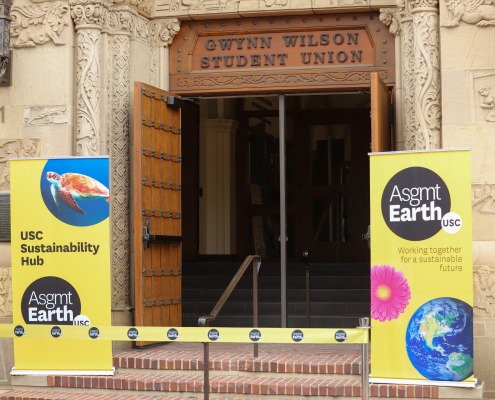 The open doors to the Wilson Student Union. Two yellow banners are beside the door to celebrate the opening of the Sustainability Hub.