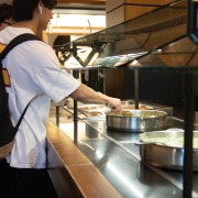 Students in the Village Dining Hall scooping food.