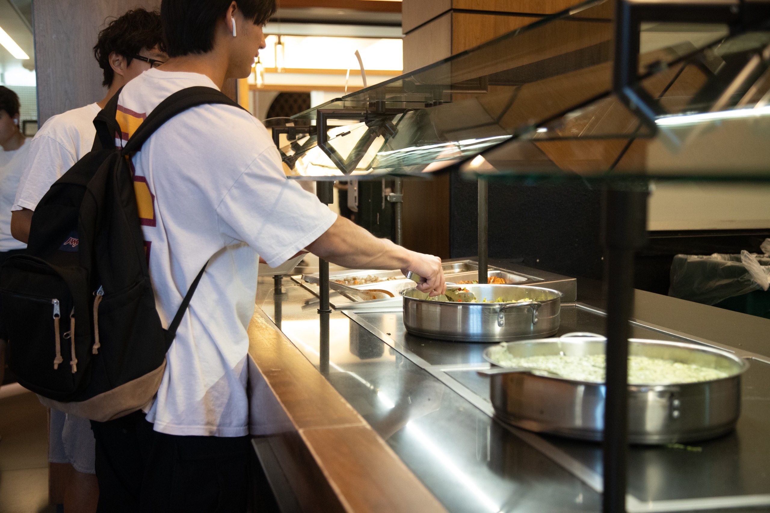 Students in the Village Dining Hall scooping food.