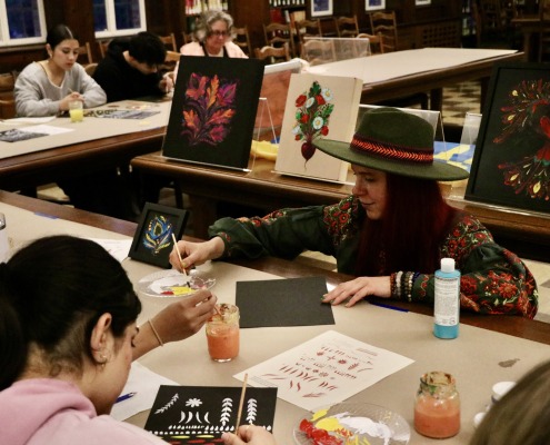 Artist Marina Malyarenko and students painting at the "Voices of Freedom, Voices of War in Ukraine: Readings and Conversations" event.