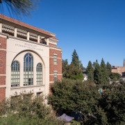 Side view of the facade of the Engemann Student Health Center, with pointed windows amid a cream-colored face.