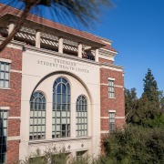 Side view of the facade of the Engemann Student Health Center, with pointed windows amid a cream-colored face.