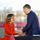 USC President Carol Folt and football Head Coach Lincoln Riley shaking hands at a 2021 press conference.