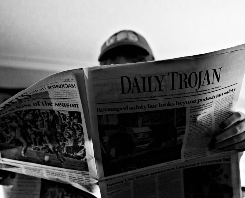 Stock someone reading Daily Trojan black and white