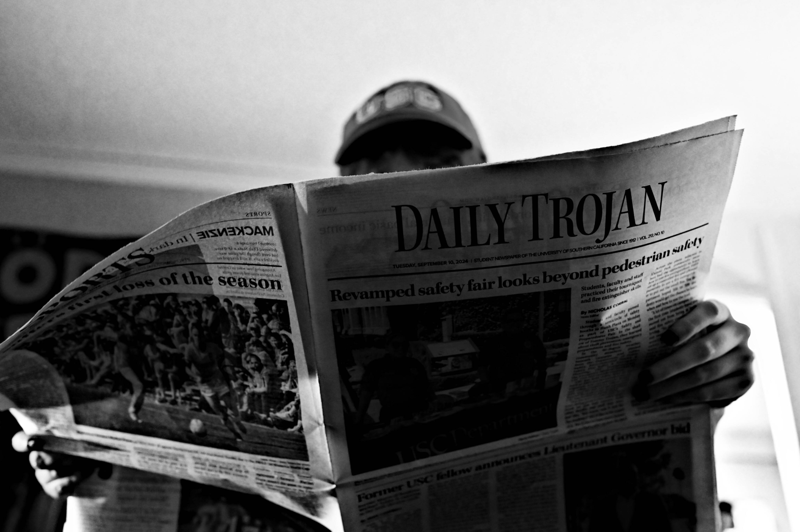 Stock someone reading Daily Trojan black and white