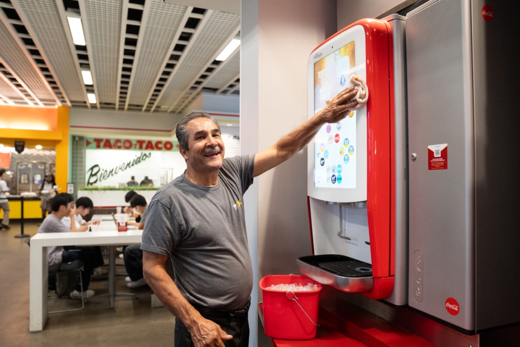 Hospitality staff in TCC (Mallory Snyder / Daily Trojan) Custodian man wiping down a vending machine.