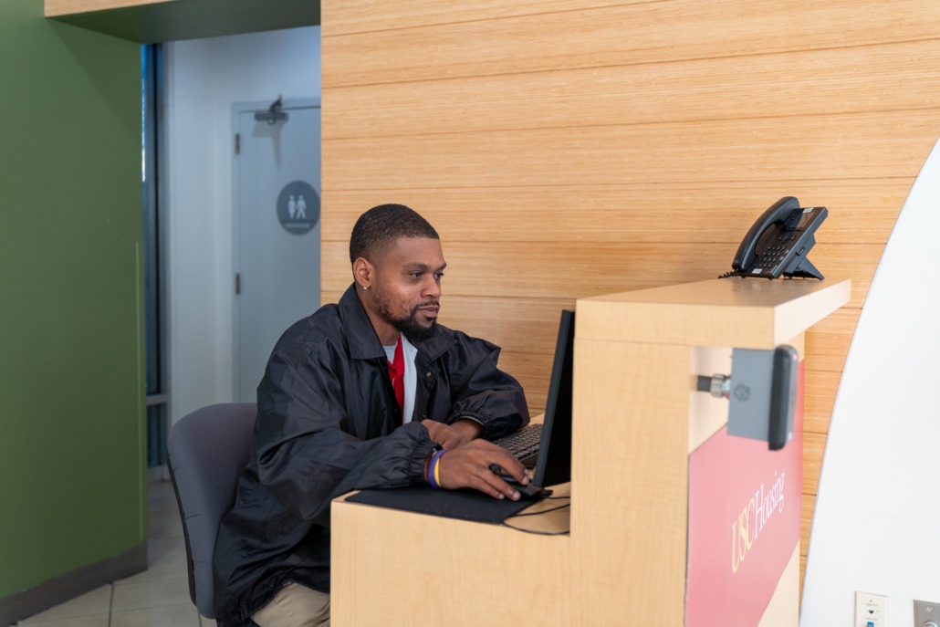 Security staff in residence halls (Mallory Snyder / Daily Trojan) USC housing front desk security sitting at his desk.