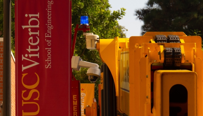 A construction vehicle idles next to a flag representing the Viterbi School of Engineering. (Luis Ochea / Daily Trojan)