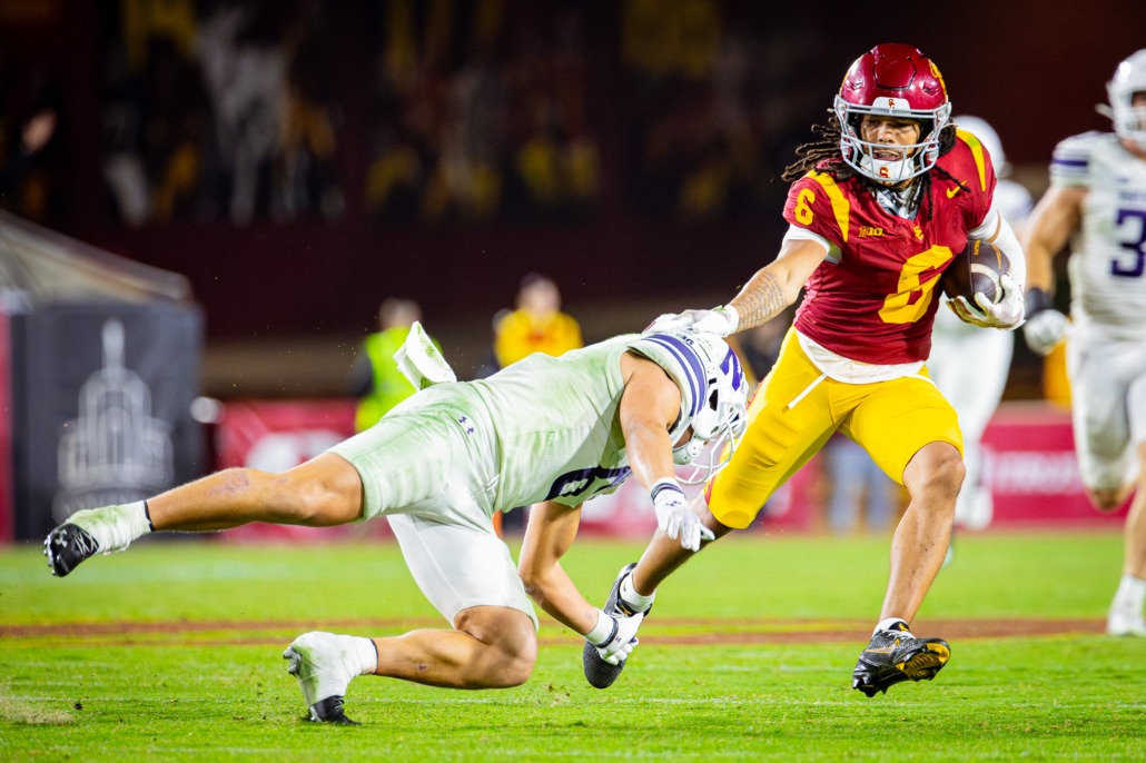 USC junior wide receiver Makai Lemon stiff arms a Northwestern defender.