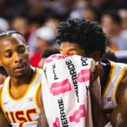 USC men's basketball players sit on the bench during a game