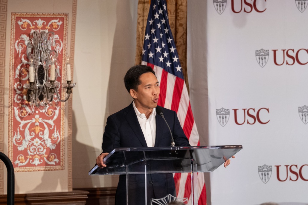 USC President Beong-Soo Kim standing at a podium with an American flag in the background