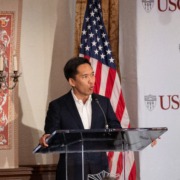 USC President Beong-Soo Kim standing at a podium with an American flag in the background