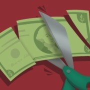 Art of a dollar bill being cut up by scissors.