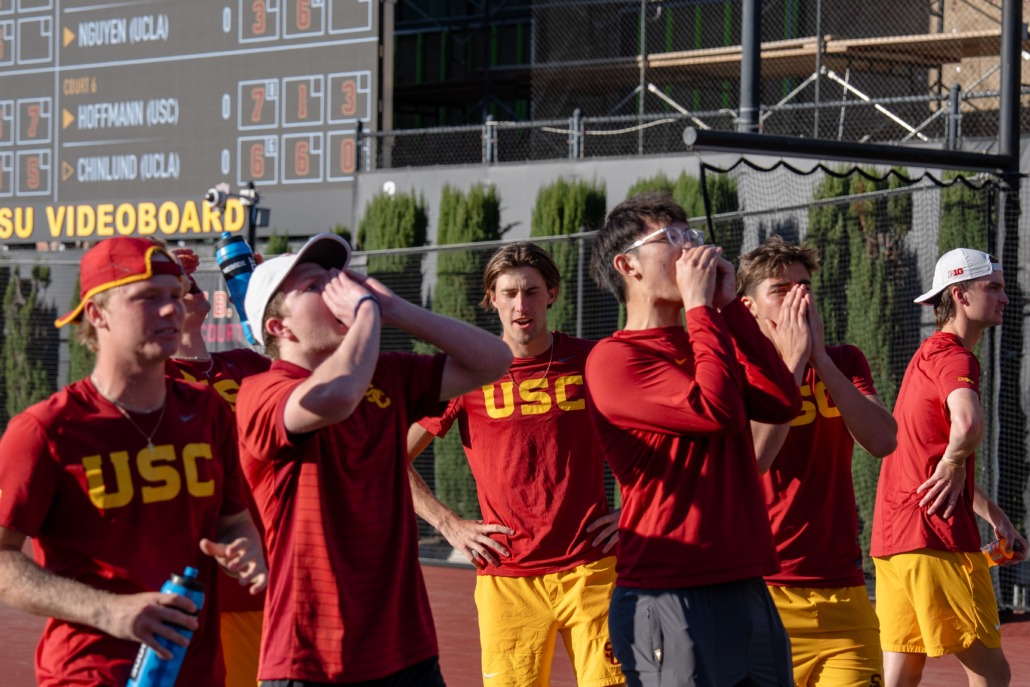 The USC men's tennis team cheers on their teammate