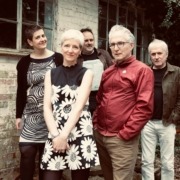 Heavenly the band stand in front of a brick wall.