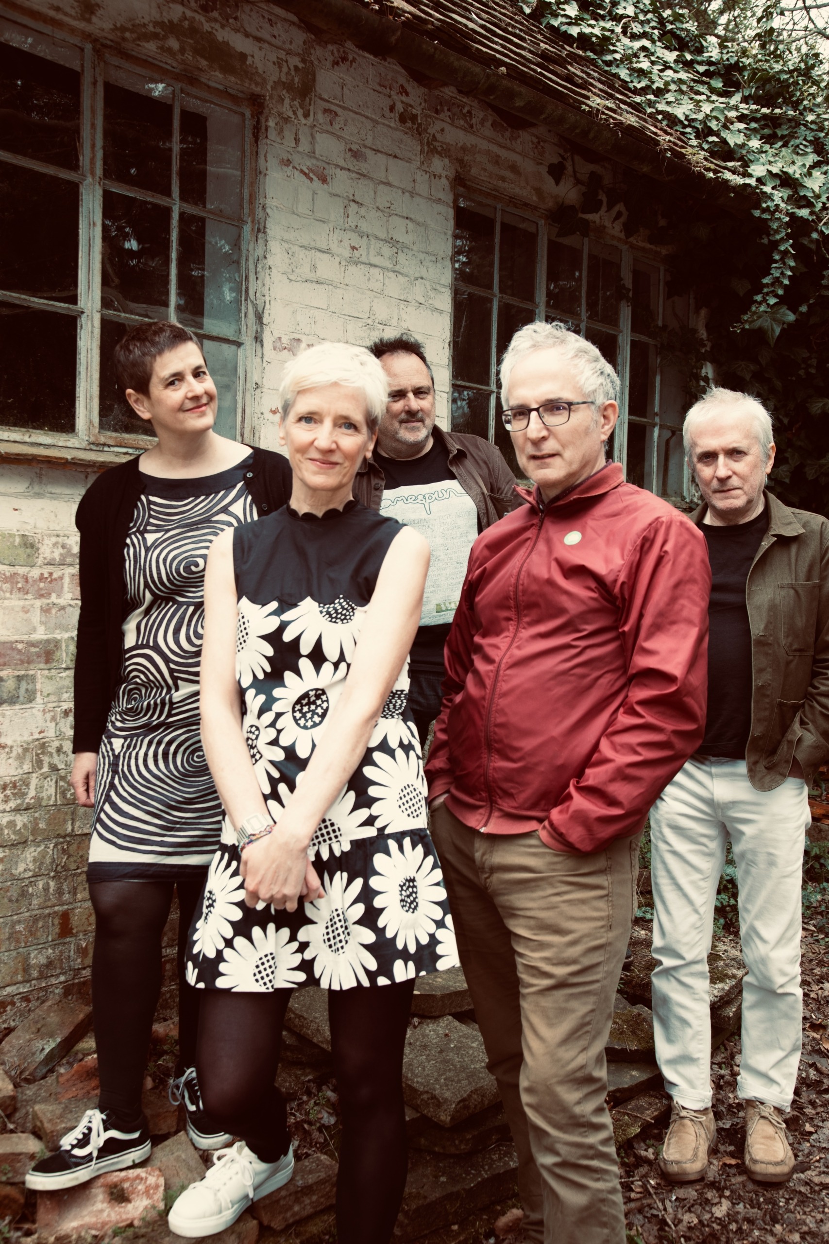 Heavenly the band stand in front of a brick wall.