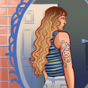 Woman looking at tattoo on arm in the mirror.