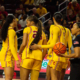 Women's basketball team gathers under the basket.