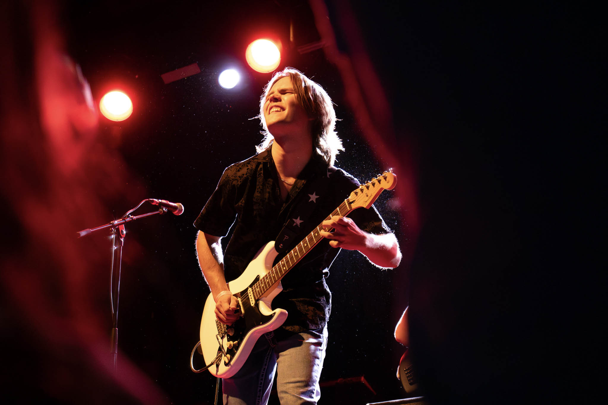 A guitar player rocks on stage at the pop showcase.