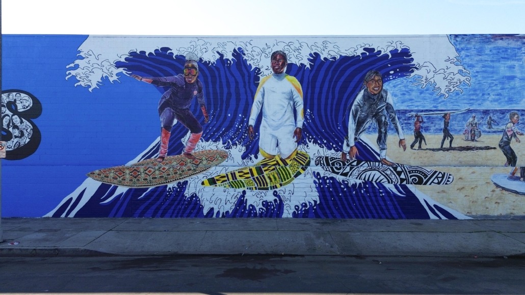 A mural of three children surfing
