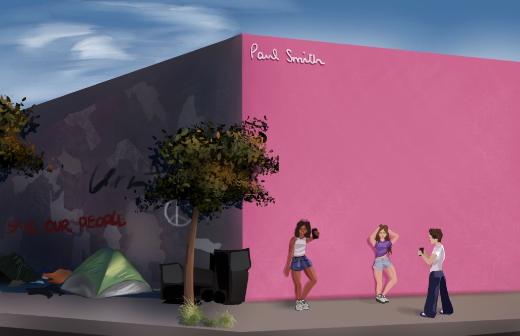 Three people doing a photoshoot at the famous L.A. pink wall while the other side of the wall features homelessness and graffiti .