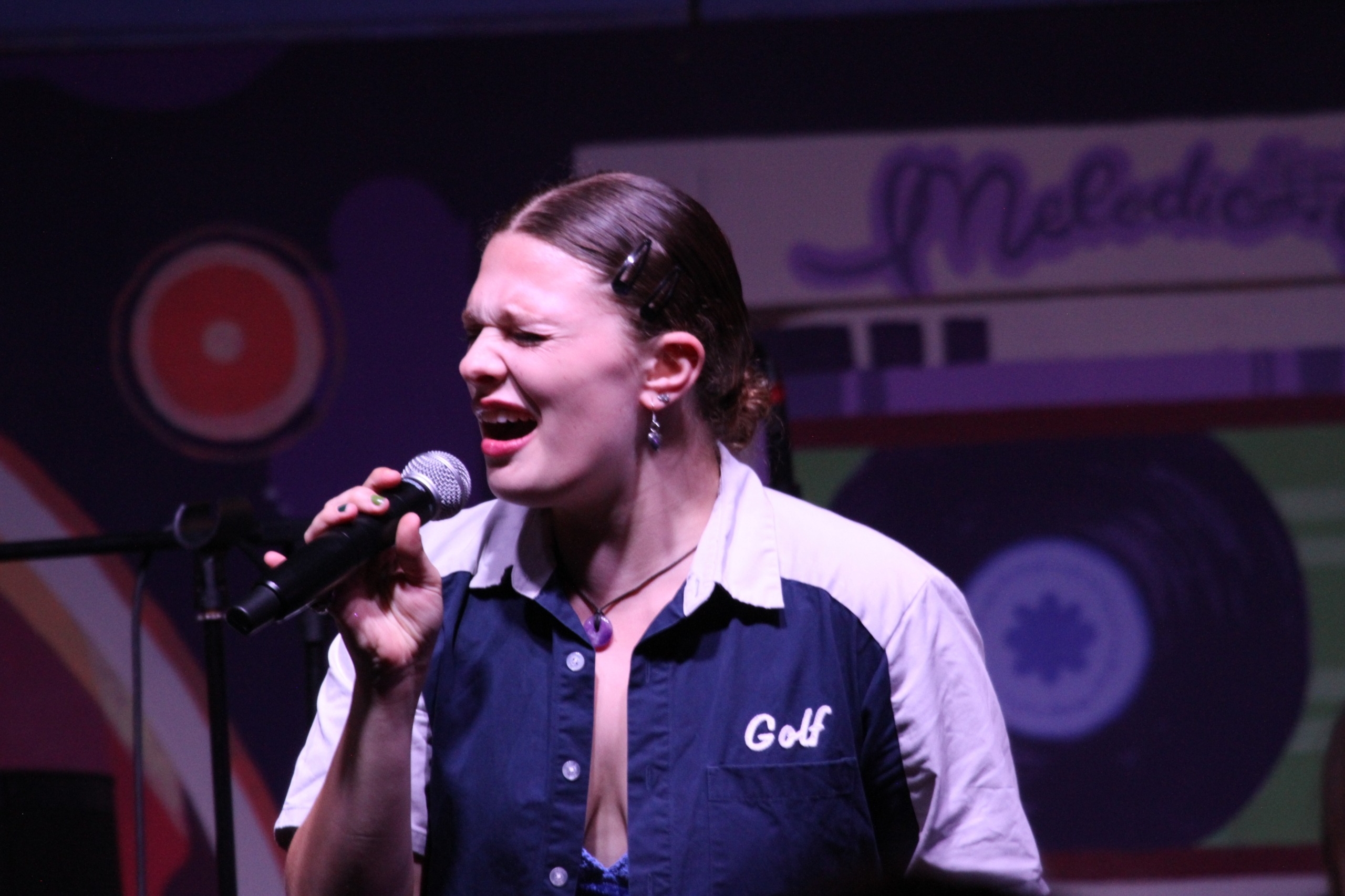 Small Talk's Sammi Walis sings into microphone.