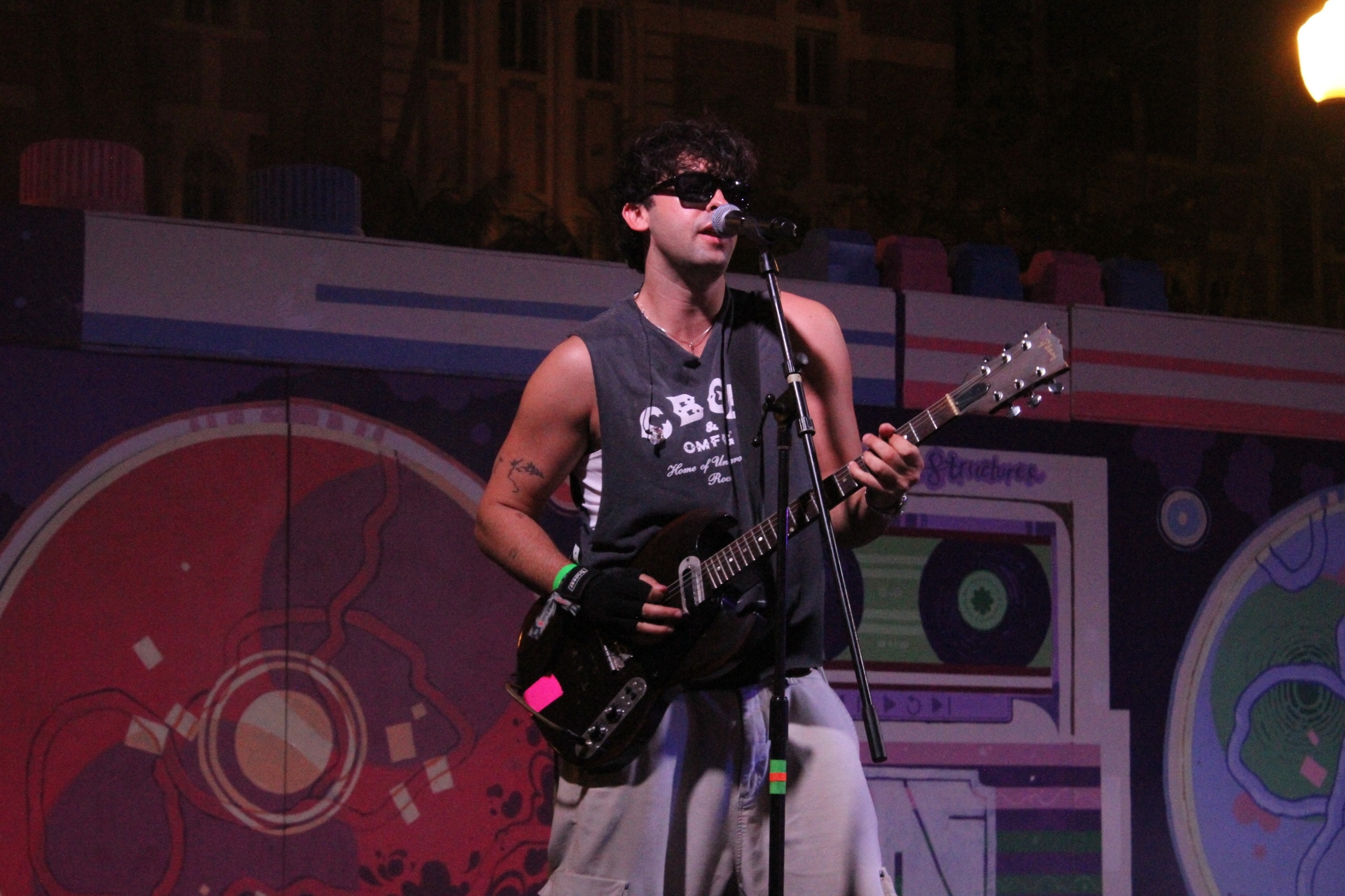 Brandon Hudson of BETWEEN FRIENDS plays the guitar while singing.