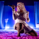 Slayyyter performing on a pink and blue stage.