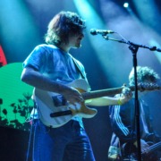 A man plays a guitar on stage.