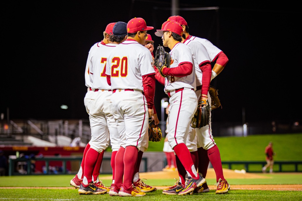 The baseball team huddles up before taking the field.
