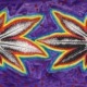 Two cannabis leaves with a rainbow around them
