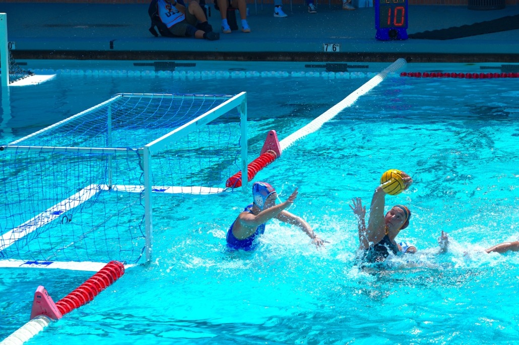 A women's water polo player shoots against UCLA