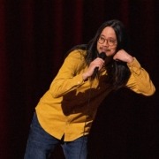 Sheng Wang performs on stage microphone in hand.