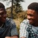 Two men smiling and talking to each other.