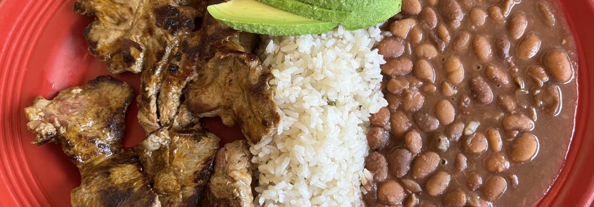 The carne asada platter from La Maria features fried plantains, avocado, beans and rice.