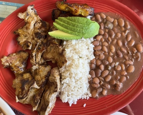 The carne asada platter from La Maria features fried plantains, avocado, beans and rice.