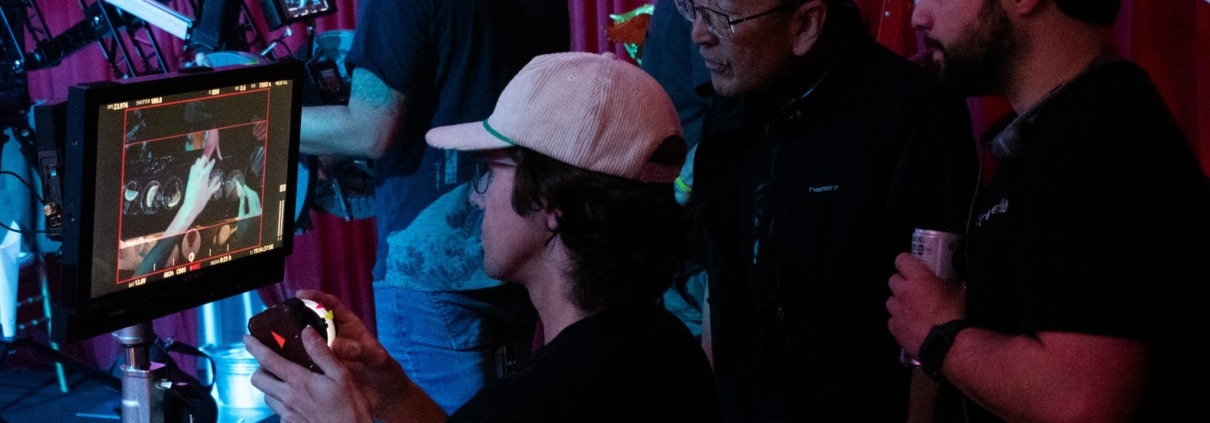 John Kim and the crew of "Reunion" behind the scenes of filming looking at the camera monitor