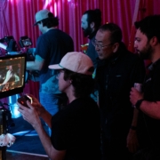 John Kim and the crew of "Reunion" behind the scenes of filming looking at the camera monitor