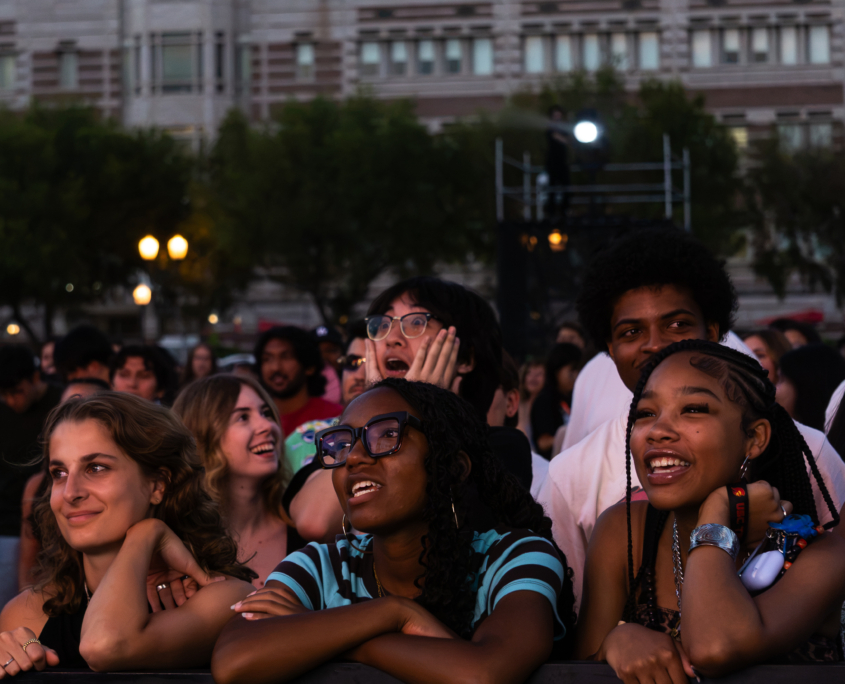 Front row audience members smiling during the concert.