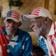 Albert Brayboy Sr. and Albert Brayboy Jr. sit next to each other, cld in U.S.A. merchandise.