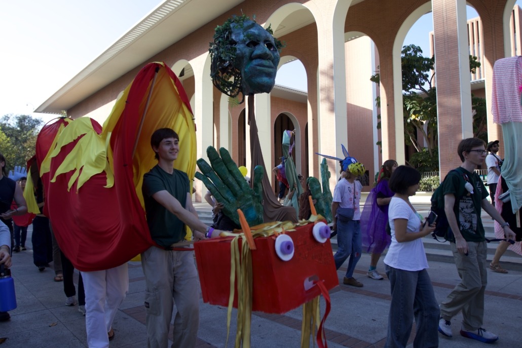 Person walking with long orange and red dragon puppet.
